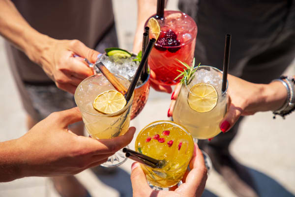 A group of friends holding their drinks together near The Courts of Avalon in Pikesville, Maryland