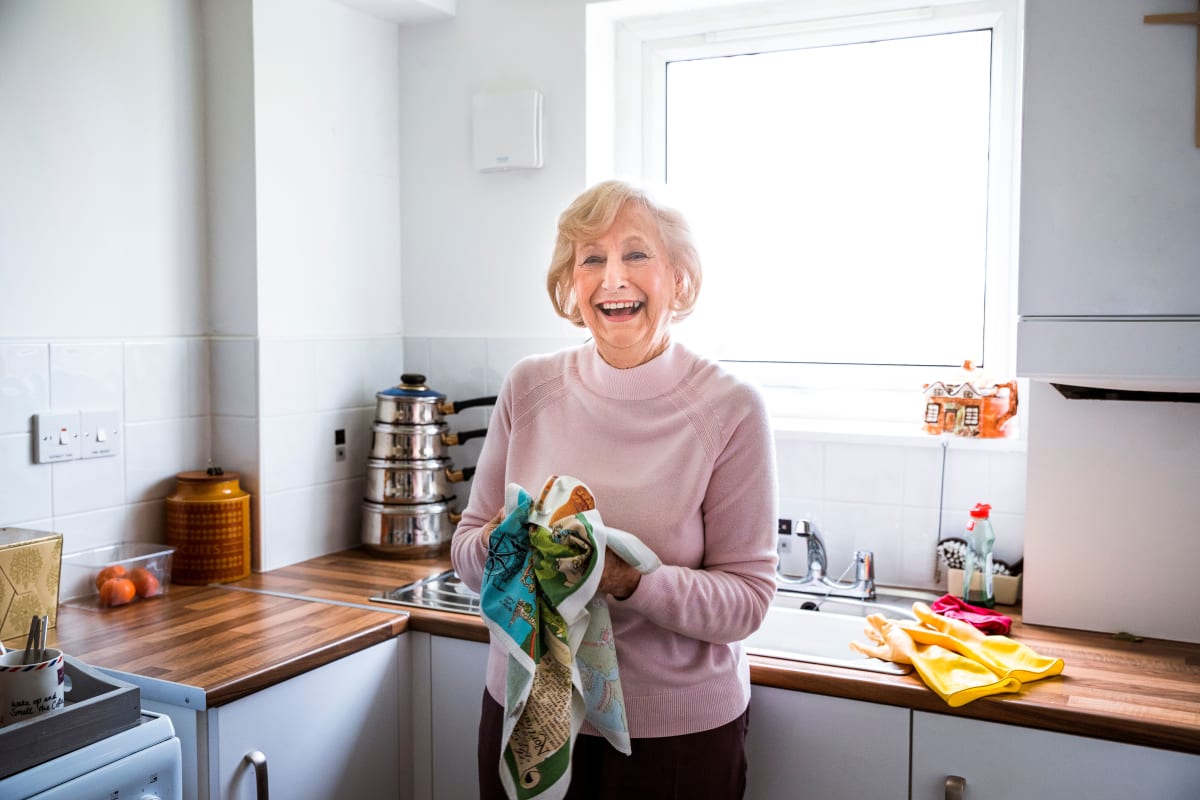 A resident doing the dishes in her apartment at a Meridian Senior Living Independent Living community