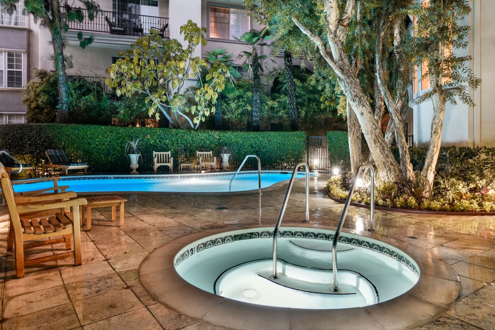 Hot tub and pool area surrounded by luscious greenery at L'Estancia in Studio City, California