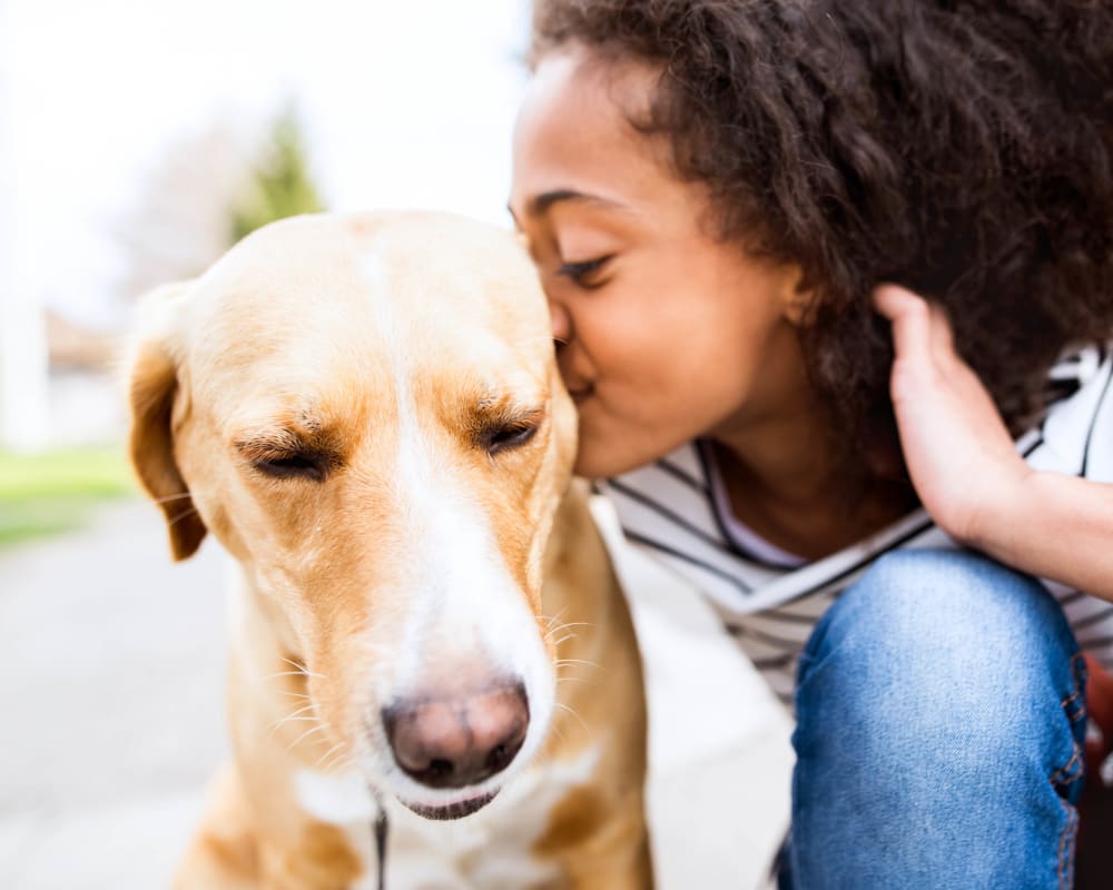 Child giving her dog a big kiss outside at The Enclave in Brunswick, Georgia