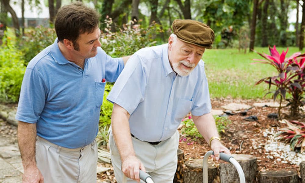 A caretaker from Chestnut Knoll at Home in Boyertown, Pennsylvania assisting a resident on a walk