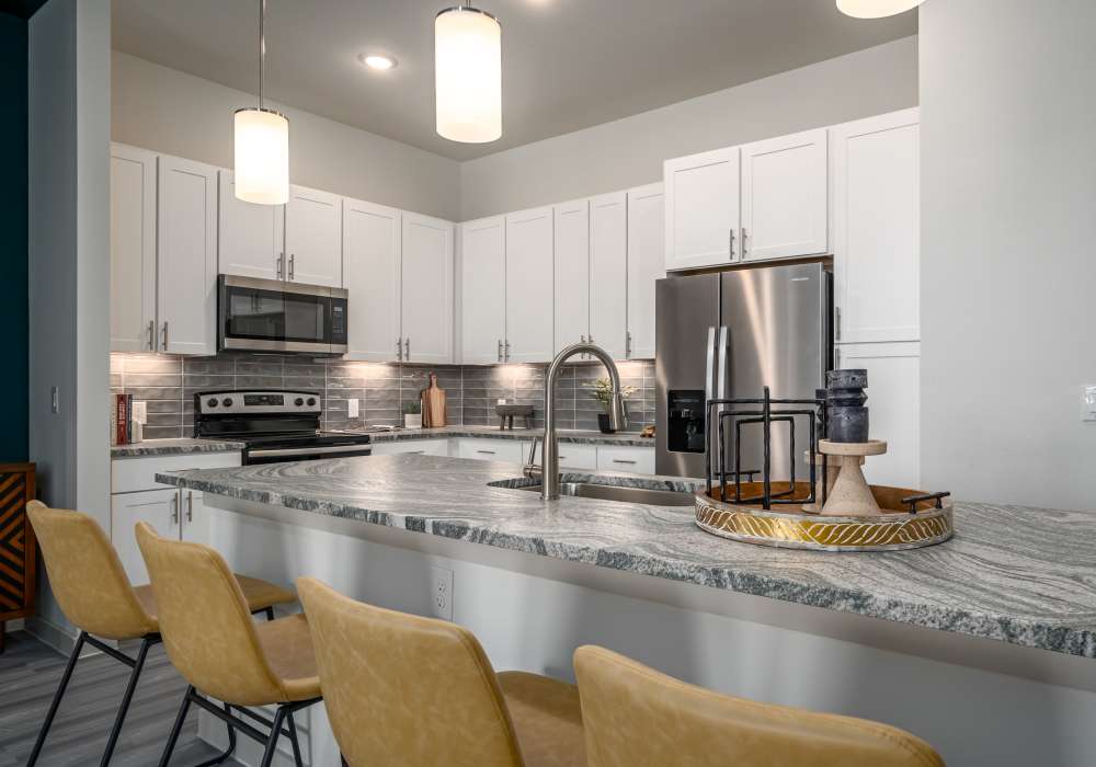 Modern apartment kitchen featuring white shaker-style cabinetry at Charleston at Fannin Station in Houston, Texas