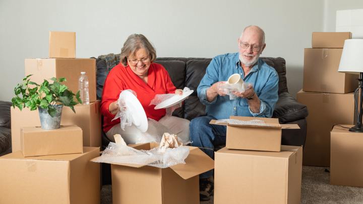 Elderly couple packing brown boxes