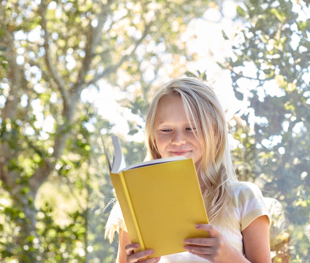 Resident child reading a book in her new home at Waterstone Fremont in Fremont, California