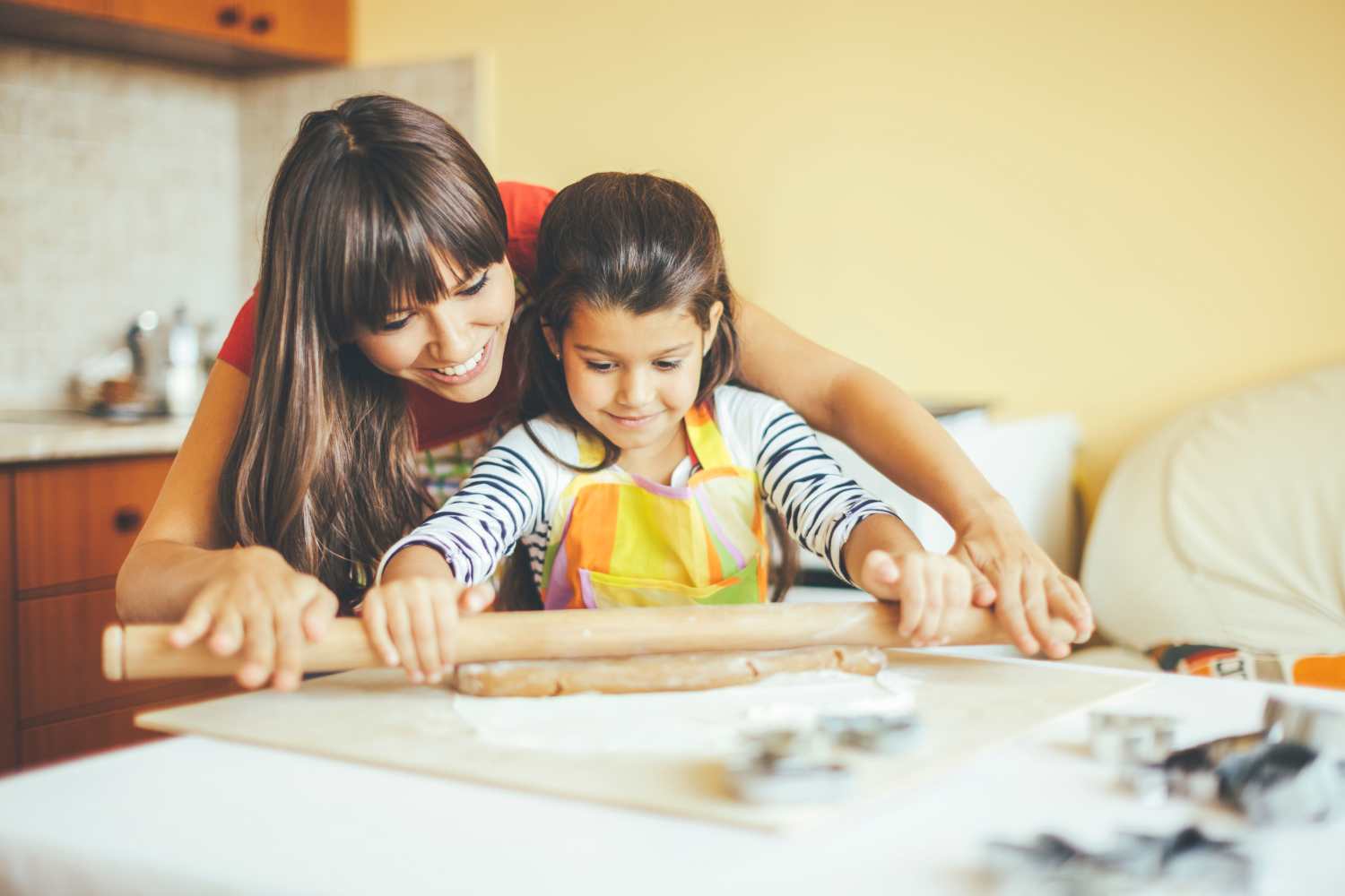 Little girl helping her mother in kitchen at Lakewood Apartments in Stockbridge, Michigan