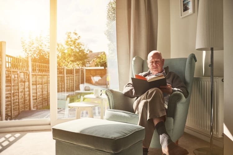 A resident reading a book in his apartment at The Harmony Collection at Hanover in Mechanicsville, Virginia