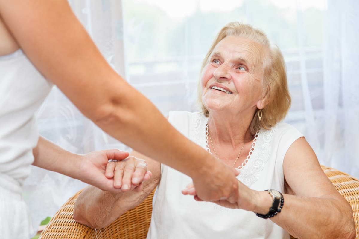 A caretaker holding a resident's hands at Keystone Place at Wooster Heights in Danbury, Connecticut