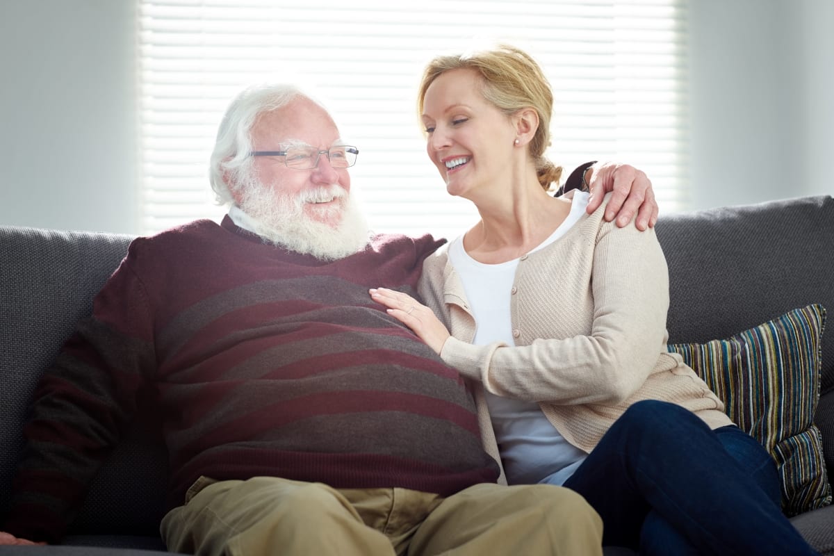 Resident with daughter sitting on a couch at The Creekside in Woodinville, Washington