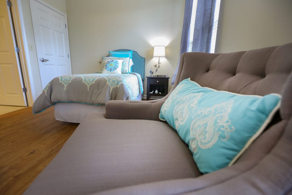 An armchair and bed in an apartment at Harmony at Waldorf in Waldorf, Maryland