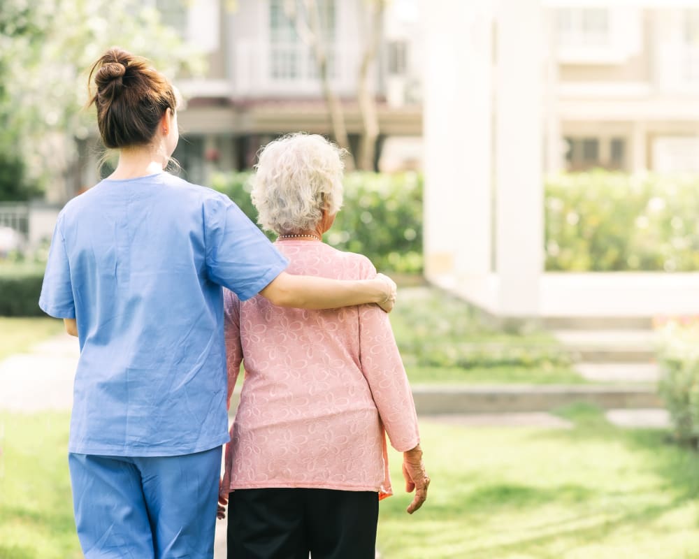Resident and staff walking together at Country Meadow Place in Mason City, Iowa.