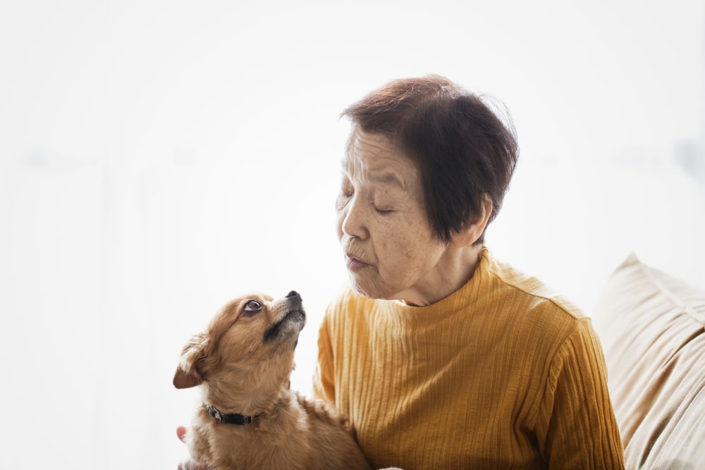 Resident smiling with pet dog at Villa Grande on Saxon in Orange City, Florida