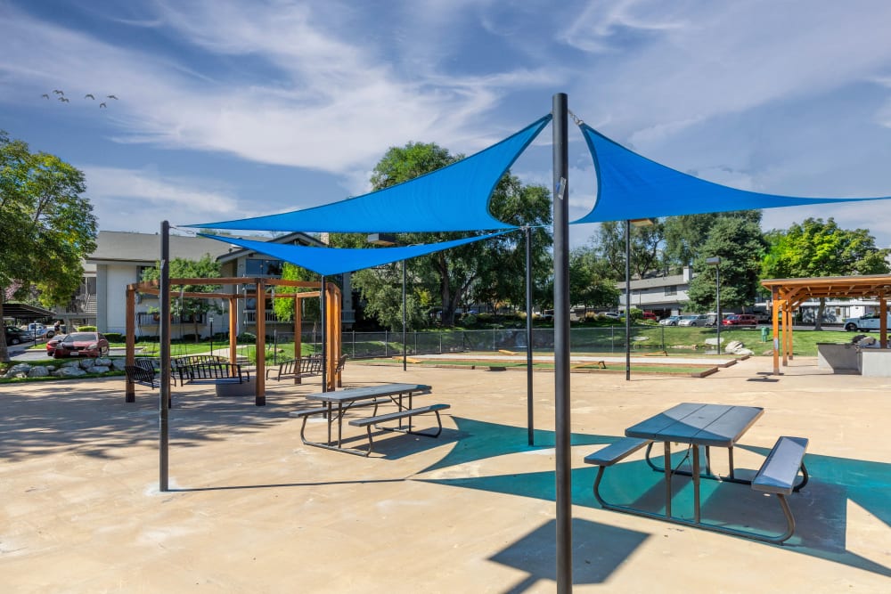 Canopy covered picnic tables at Springs of Country Woods Apartments in Midvale, Utah