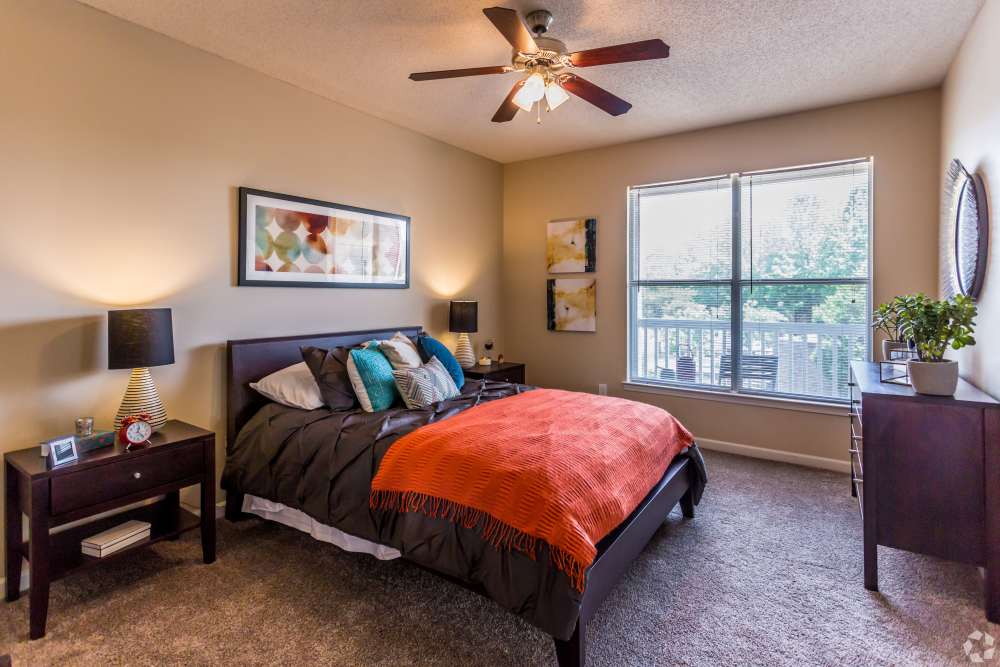 Bedroom with carpet flooring and spacious bed at Waterford Place Apartment Homes in Memphis,Tennessee