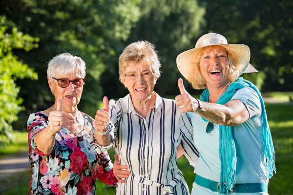 Three active adults smiling and giving a thumbs up while enjoying a nature walk in Conroe, Texas