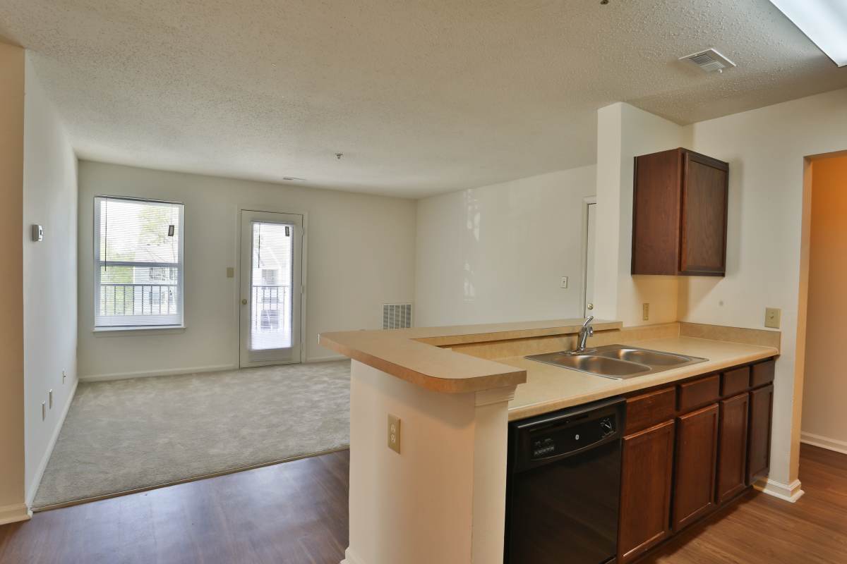 Modern kitchn with dishwasher, stainless steel sink, wood cabinet and granite countertop at Chickahominy Bluff in Mechanicsville, Virginia