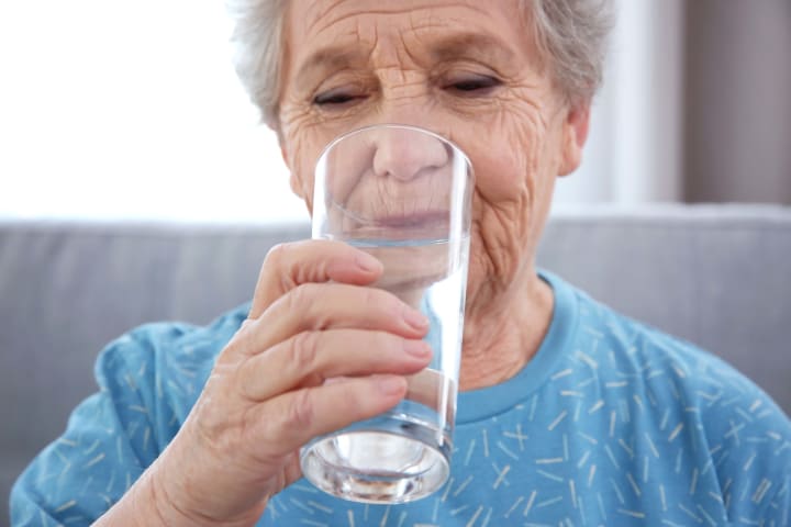 Senior woman drinking a glass of water