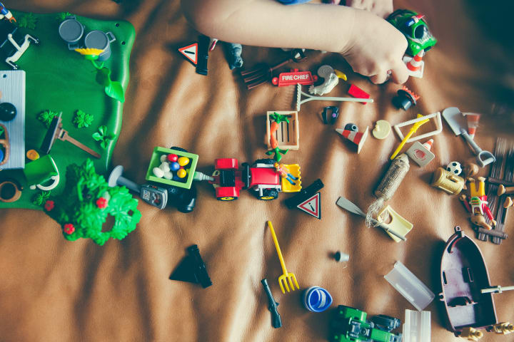 A small child going through their various toys and action figures 