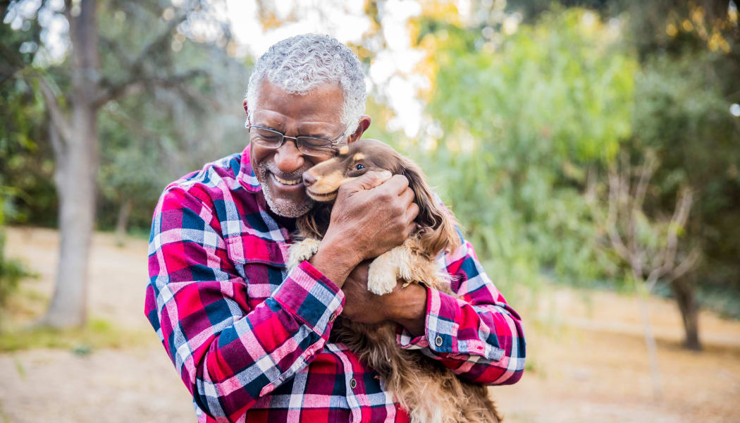 Resident and his dog enjoying the community at The Arbors of Carrollton in Carrollton, Texas