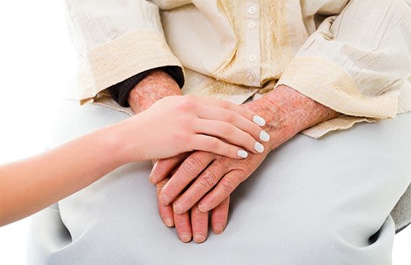 Woman holding a resident's hand at The Phoenix at Lady's Island in Beaufort, South Carolina