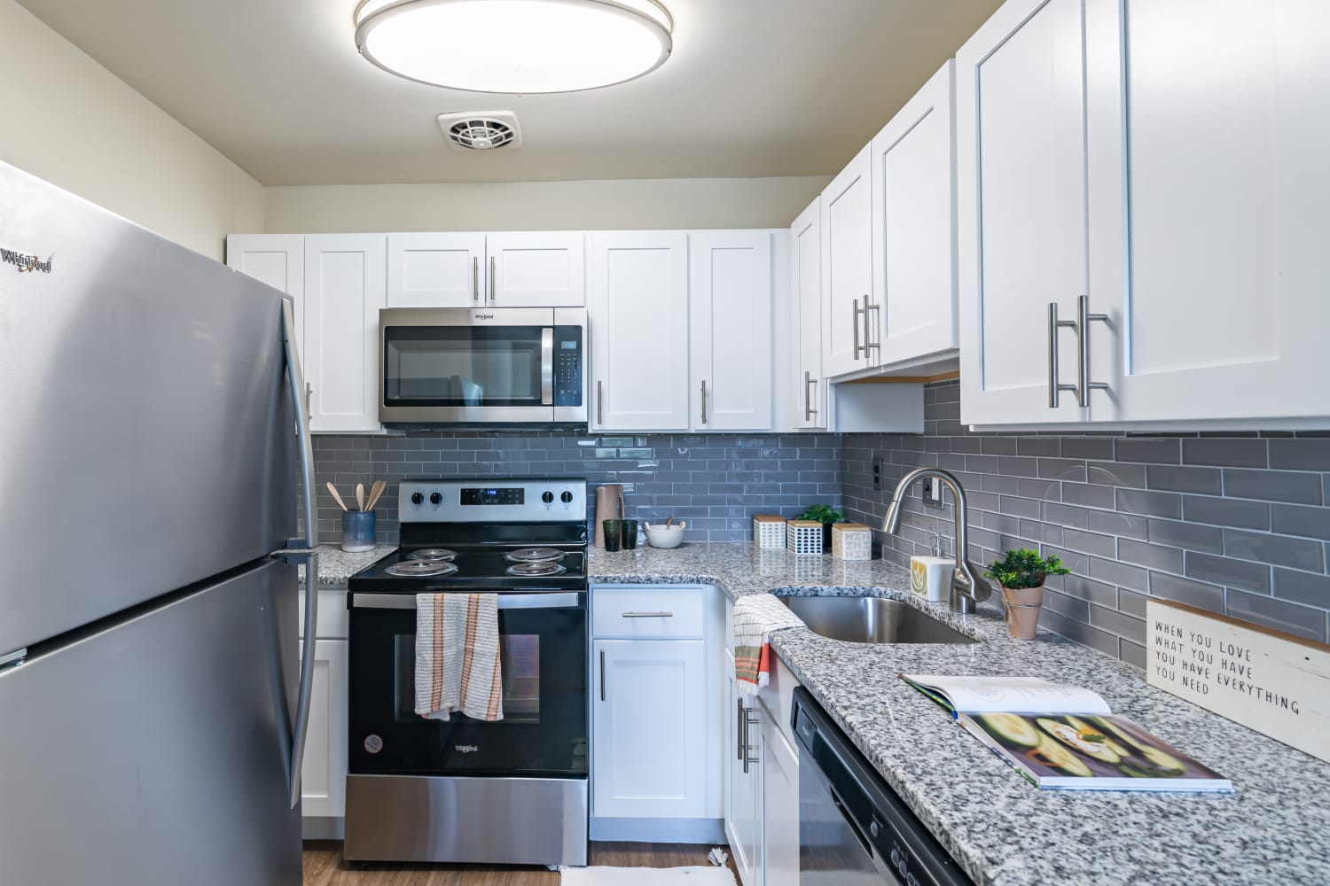 Kitchen with white cabinets, granite counters, and stainless appliances at Hyde Park Apartment Homes in Bellmawr, New Jersey
