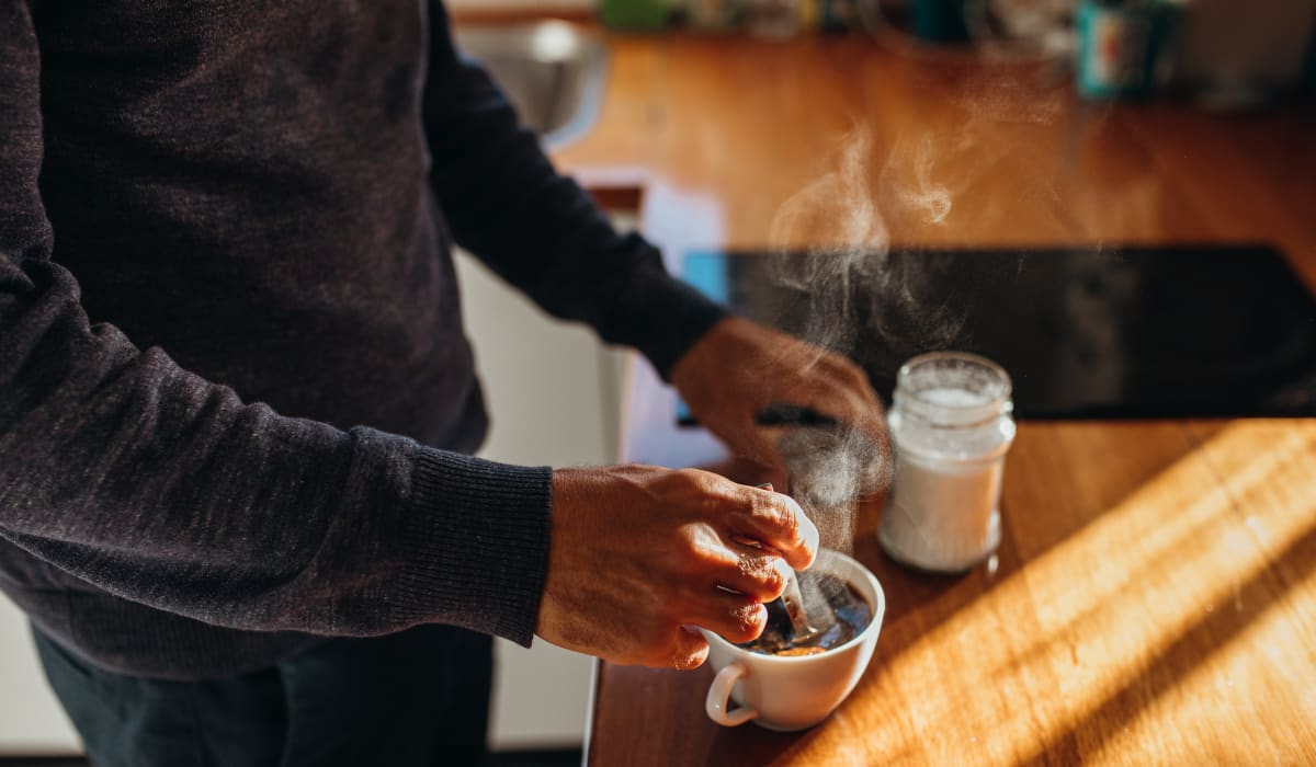 Resident making coffee in their modern kitchen at The Village of Laurel Ridge & The Encore Apartments & Townhomes in Harrisburg, Pennsylvania 