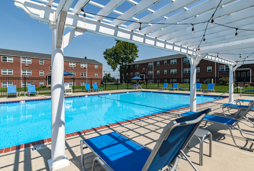 Lounge seating by the sparkling swimming pool at Hyde Park Apartment Homes in Bellmawr, New Jersey