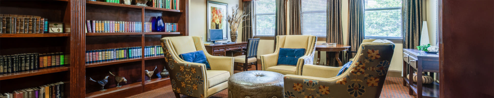 Library at Isle at Cedar Ridge in Cedar Park, Texas, featuring bookshelves and comfortable seating for reading.