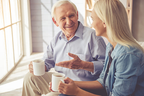Happy resident enjoying coffee with family member at Wyndham Court of Plano in Plano, Texas