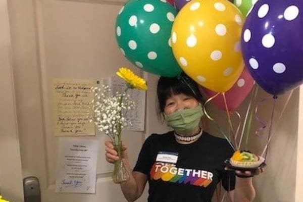 A staff member with balloons ready to greet new residents at Merrill Gardens. 