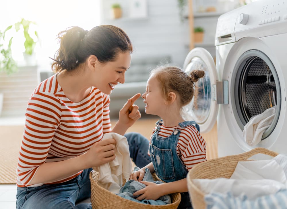 A mother and her daughter doing laundry in a home at The Village at Carolina Meadows in Chesapeake, Virginia