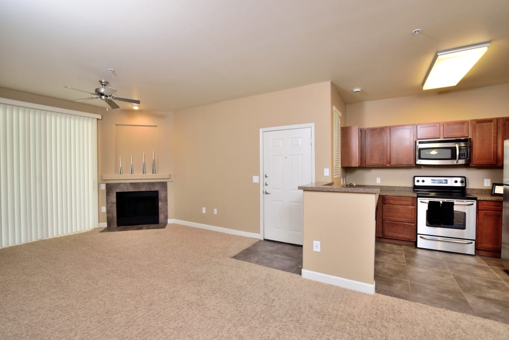 Open-concept floor plan showcasing fireplace and modern kitchen in apartment home at Lumiere Chandler in Chandler, AZ