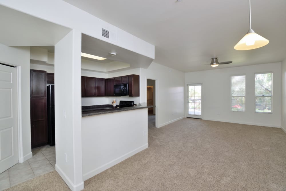 Large, open living room with modern kitchen in the background in apartment home at Lumiere Chandler in Chandler, AZ