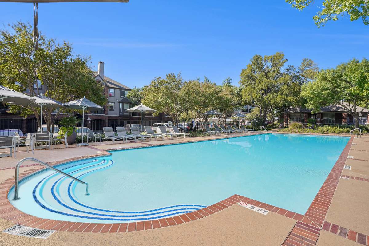 Swimming pool and patio with lounge chairs at The Estate on Quarry Lake, Austin, Texas