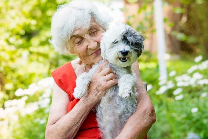 Resident enjoying time with her dog at Watermere at Firewheel in Garland, TX, highlighting the pet-friendly independent living community.