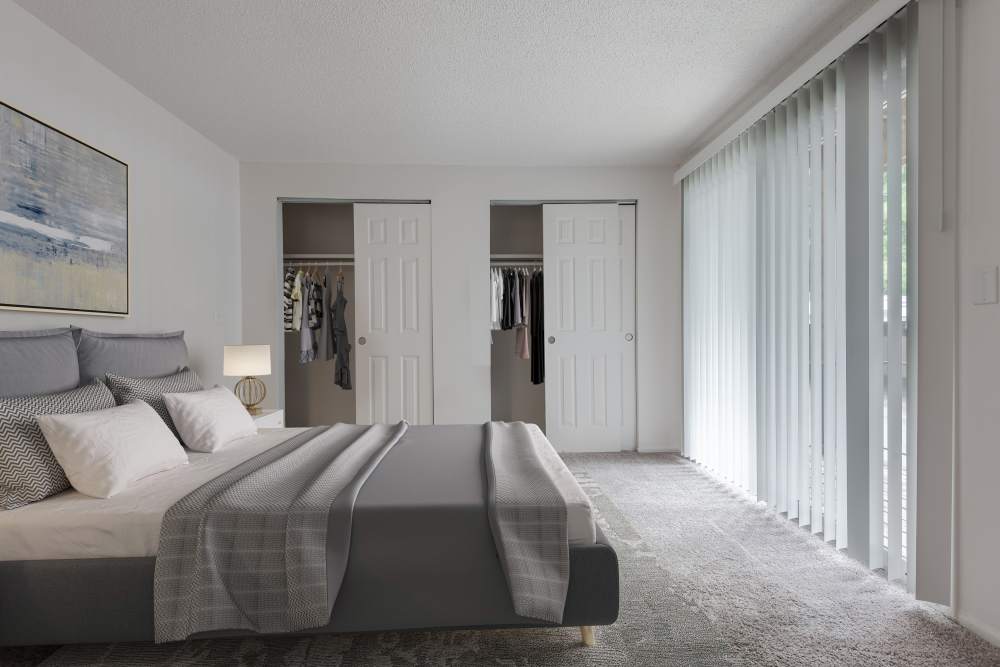Staged bedroom with wall to wall carpeting at Creek Hill Apartments in Webster, New York
