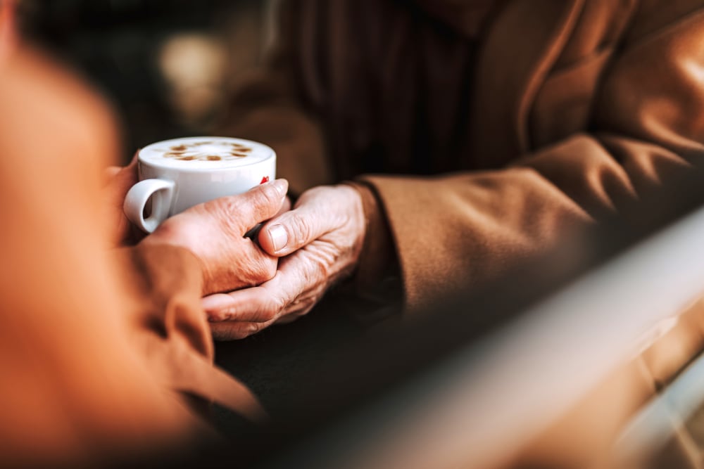 A resident holding a cup of coffee at The Claiborne at Newnan Lakes in Newnan, Georgia. 