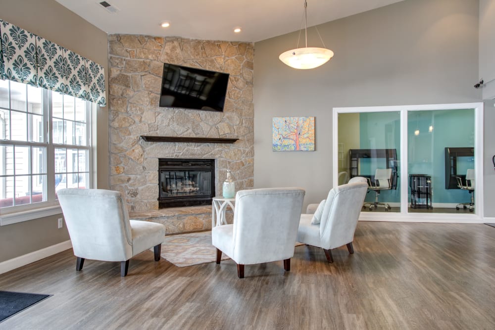 A spacious clubhouse with a fireplace and comfortable seating at Greenway Chase in Florissant, Missouri