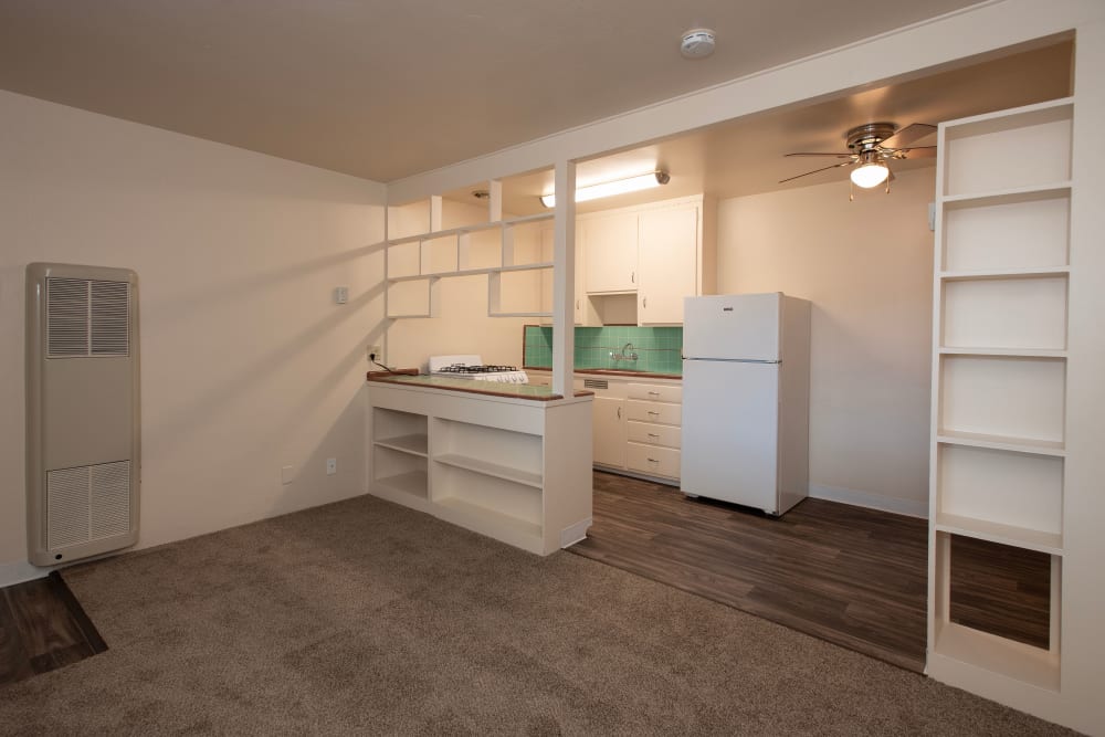 Kitchen and living area with shelving at Coralaire Apartments in Sacramento, California
