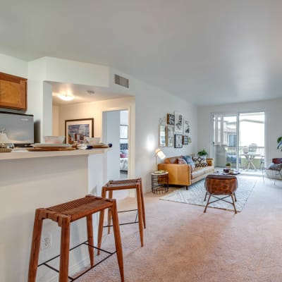 Open-concept layout with plush carpeting in a model home at Sofi at Topanga Canyon in Chatsworth, California