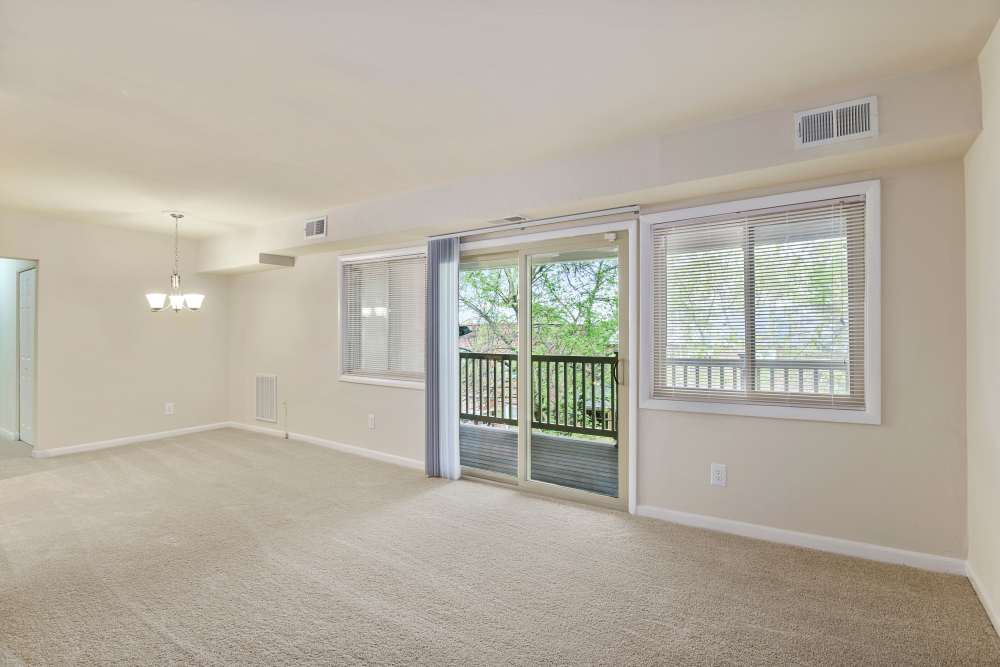 Unfurnished living room with carpet flooring showing access to patio at Cross Creek in Laurel, Maryland
