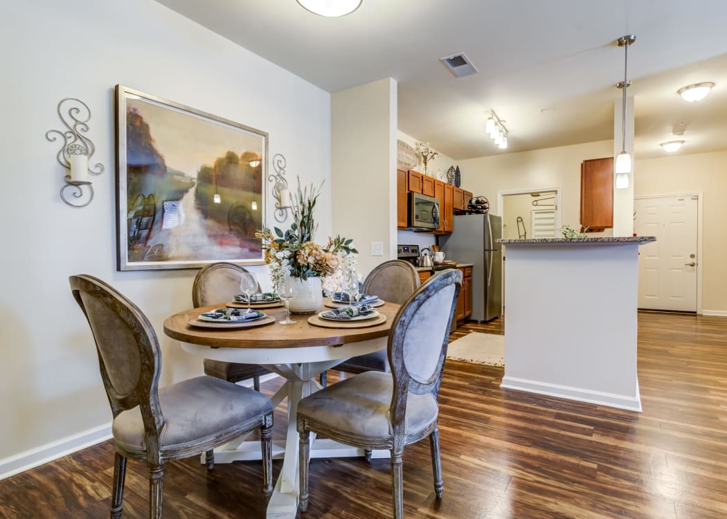 Cozy dining room with wood-style flooring in a model home at Commonwealth at 31 in Spring Hill, Tennessee