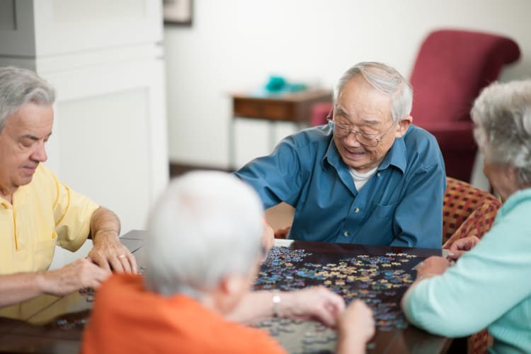 A group of residents putting together a puzzle at The Harmony Collection at Columbia Assisted Living & Memory Care in Columbia, South Carolina