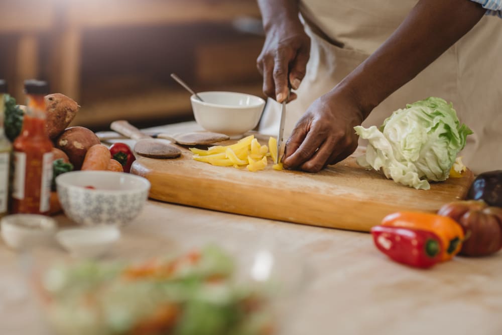 Resident chopping vegetables for a fresh meal in his fully equipped kitchen at Steeplechase Apartments & Townhomes in Toledo, Ohio