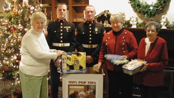 Residents and military members with toys for tots at {{location_name}} in {{location_city}}, {{location_state_name}}