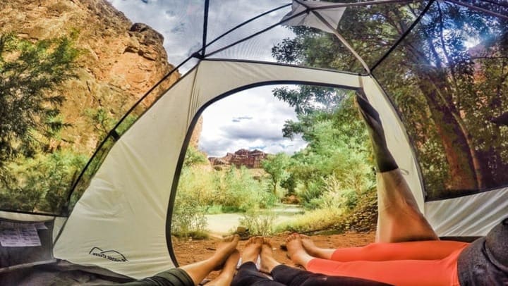 feet sticking out of tent facing desert scenery