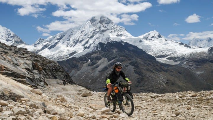 woman on bike with mountains in the background