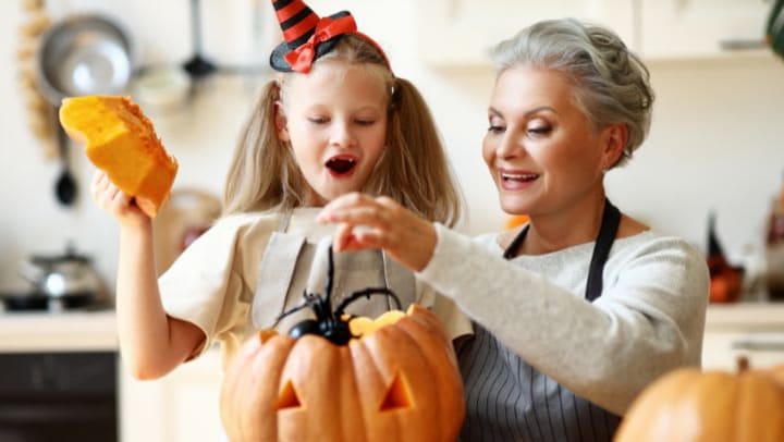 Grandmother and Granddaughter carving pumpkin