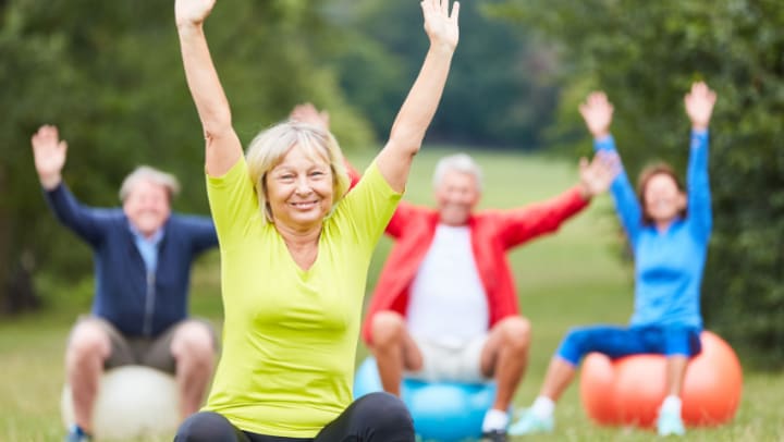 a group of elderly people exercising outdoors