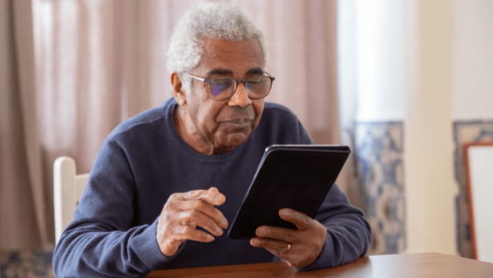 an old man looking for the news on his digital tablet 