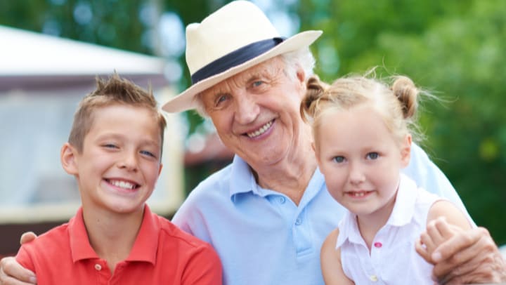 a grandfather smiling with his grandchildren